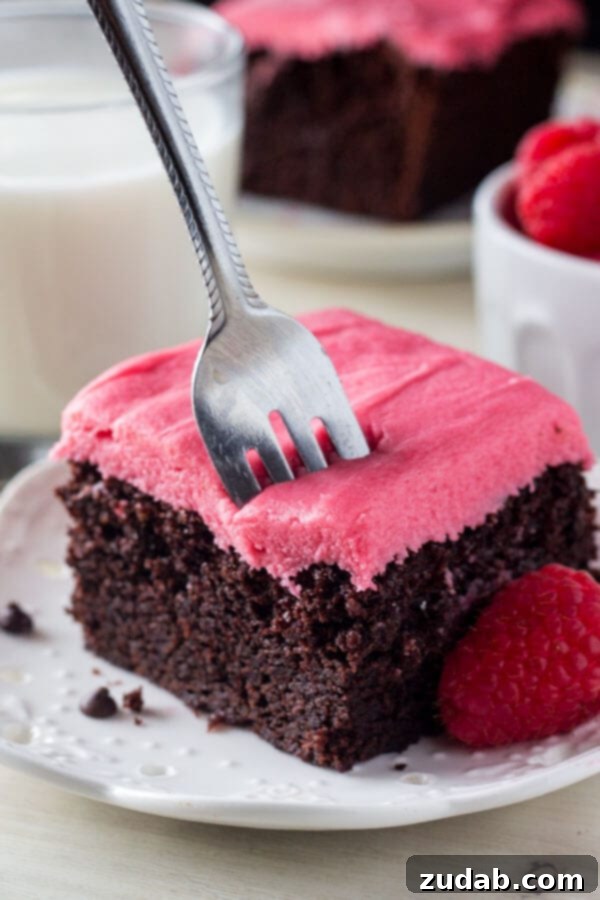 Strawberry Kissed Vanilla Dream 6 A stunning photo of a fudgy chocolate cake topped with delicate pink raspberry frosting, showcasing a delightful dessert pairing.