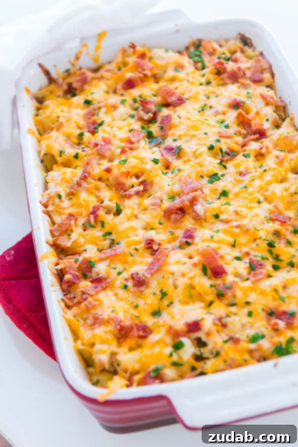 A hearty and cheesy chicken bacon ranch casserole, perfect for a satisfying dinner. ohsweetbasil.com Hearty chicken bacon ranch casserole in a vibrant red casserole dish, ready to be served.