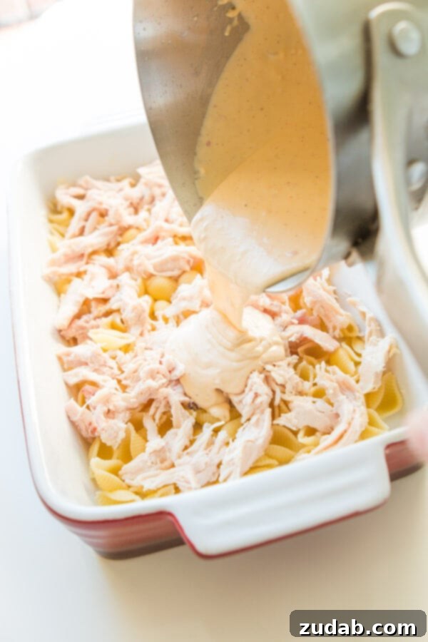 Irresistible Cheesy Chicken Bacon Ranch Casserole 4 Layering the ingredients in a casserole dish for a delicious chicken bacon ranch casserole.