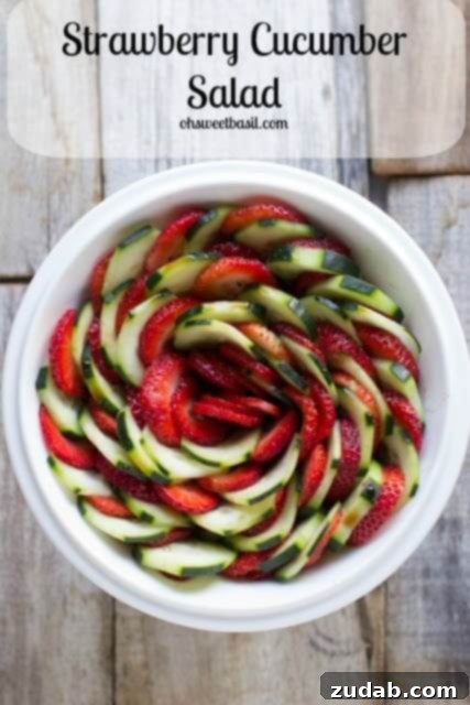 Effortless Caprese Delight 4 A vibrant Strawberry Cucumber Salad in a clear bowl, glistening with a light honey balsamic dressing, featuring fresh strawberries, cucumber slices, and mint leaves.