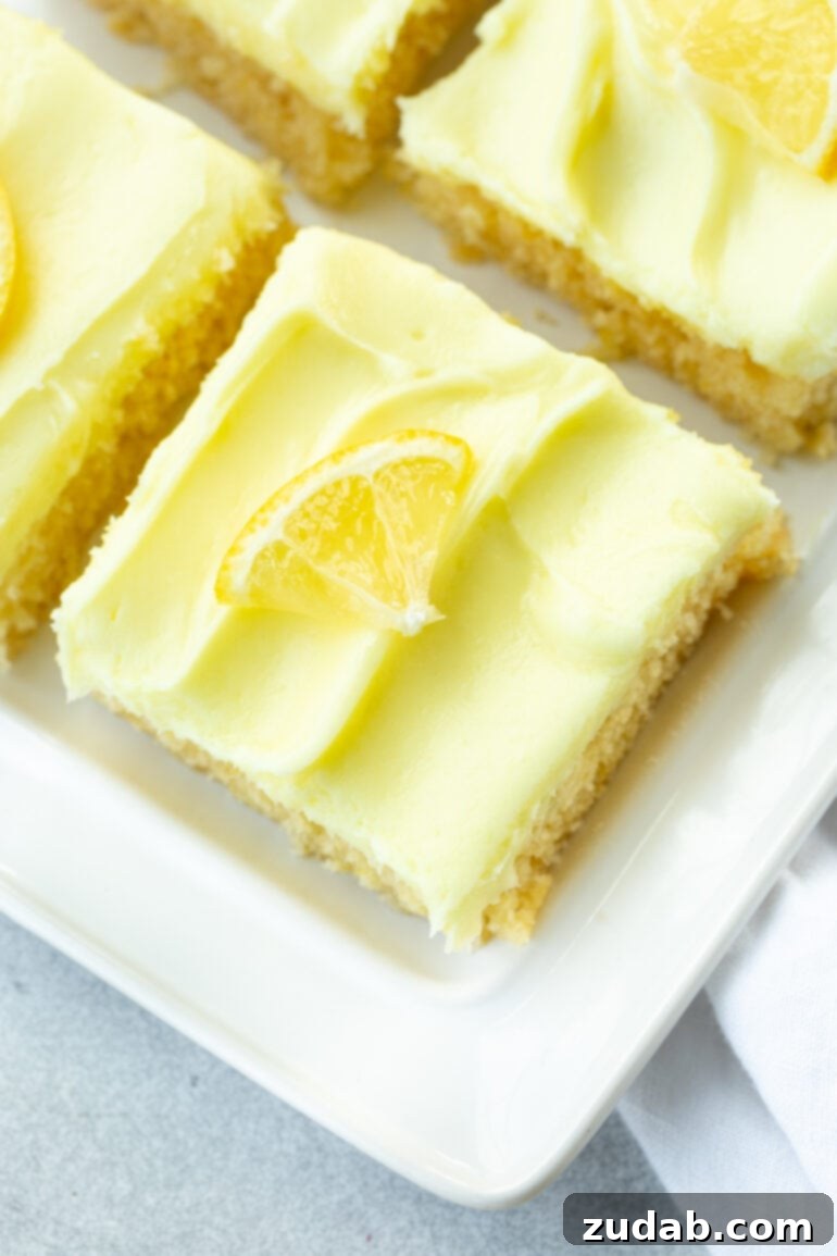 Zesty Lemon Cake with Lemon Cream Cheese Frosting 7 A perfectly square piece of moist lemon cake, beautifully topped with a swirl of light yellow creamy lemon cream cheese frosting.