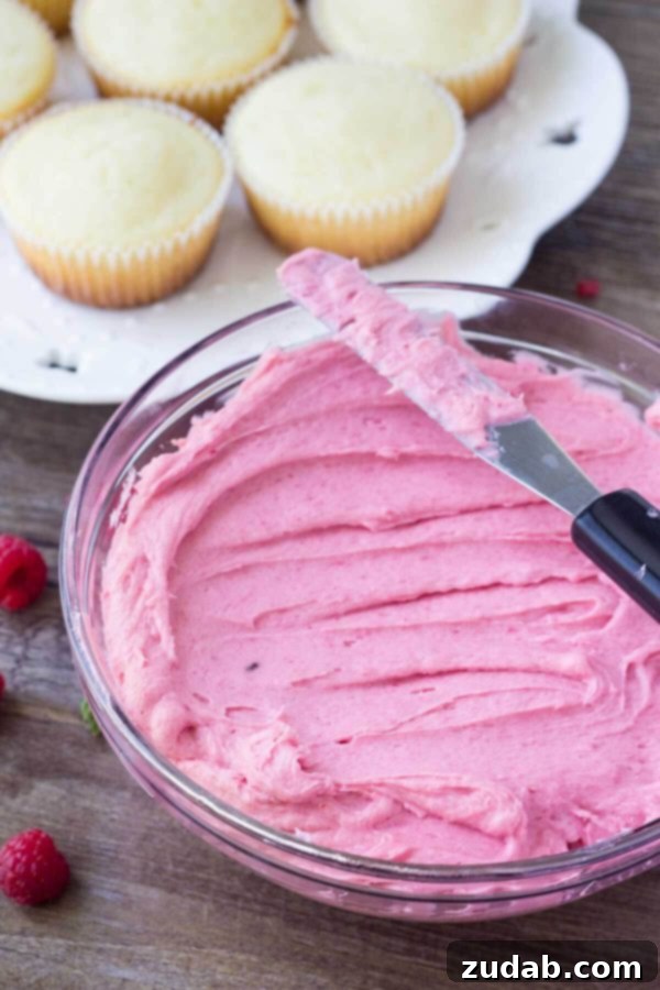 Delicately piped raspberry buttercream on a lime cupcake base. A close-up shot of Raspberry Lime Cupcakes with elegant pink frosting.