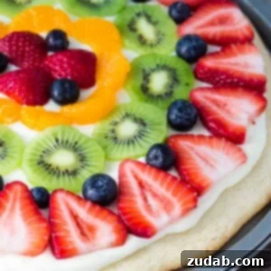 This sugar cookie fruit pizza is perfect for summer. Decorated with tangy cream cheese frosting and fresh fruit - it looks and tastes absolutely delicious.
