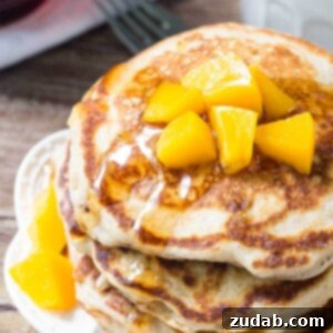 Stacked brown sugar peach pancakes with peach topping