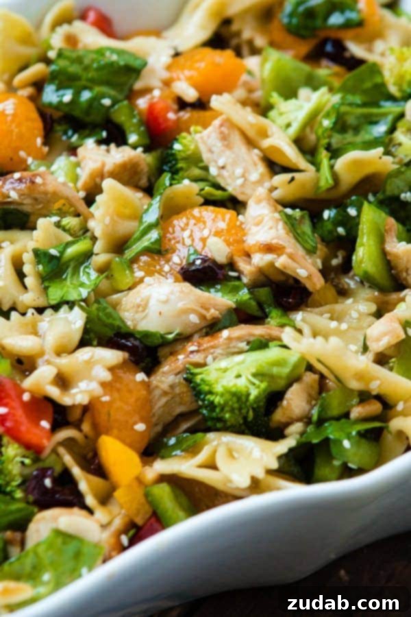 Vibrant and Flavorful Teriyaki Chicken Pasta Salad A close-up of Teriyaki Chicken Pasta Salad featuring colorful vegetables, mandarin oranges, tender pasta, and a rich sesame dressing.