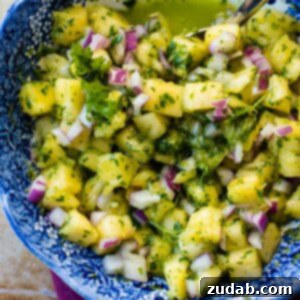 A beautifully presented bowl of 5 minute Pineapple Chimichurri with Cilantro, garnished with fresh cilantro sprigs and pineapple chunks, ready to serve.