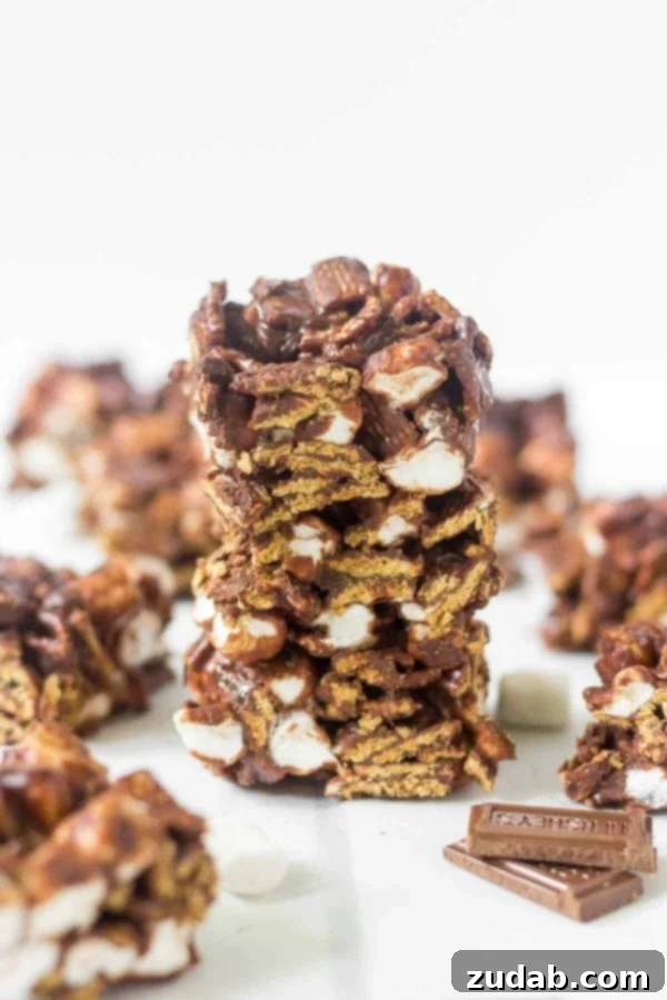 Discover the easiest no-bake s'mores bars recipe! Made with only 4 ingredients (Hershey's chocolate, mini marshmallows, Golden Grahams) in under 15 minutes, this is your perfect summer dessert. Learn how to make no bake s'mores bars at home! This simple recipe calls for 4 ingredients and takes under 15 minutes to come together. This summer dessert recipe is so yummy and easy you'll want to make it every week. Hershey's chocolate, mini marshmallows, Golden Grahams