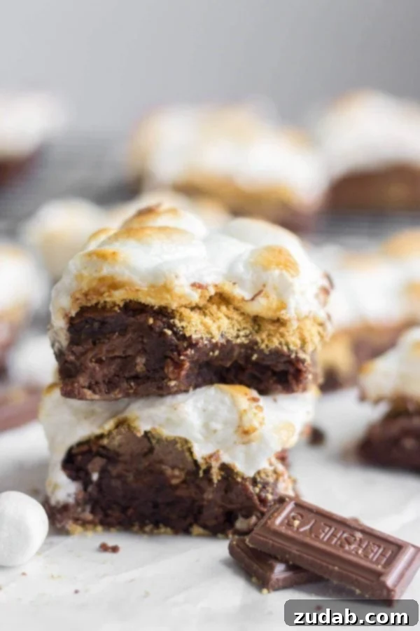 Our Best S'mores Brownies: Chewy chocolate brownies layered with graham cracker crumbs, Hershey's chocolate, and topped with toasted marshmallows for an irresistible treat. These chewy brownies are our best s'mores brownies recipe. Layered with Hershey's chocolate and graham cracker crumbs and topped with toasted marshmallows. ohsweetbasil.com