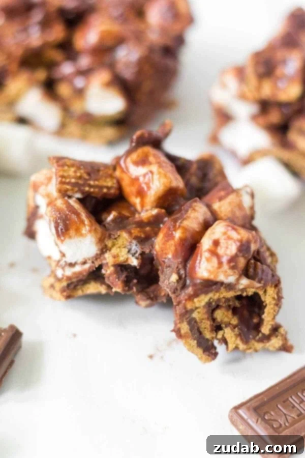 Quick and easy no-bake s'mores bars, a 4-ingredient summer dessert. Enjoy the classic taste of Hershey's chocolate, mini marshmallows, and Golden Grahams without baking. Learn how to make no bake s'mores bars at home! This simple recipe calls for 4 ingredients and takes under 15 minutes to come together. This summer dessert recipe is so yummy and easy you'll want to make it every week. Hershey's chocolate, mini marshmallows, Golden Grahams