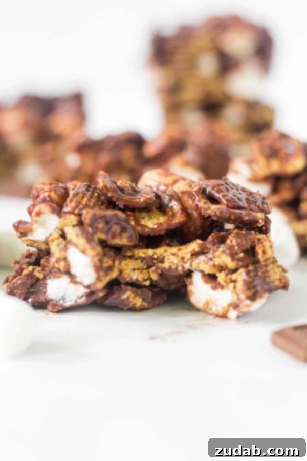The ultimate easy summer dessert: no-bake s'mores bars. Just 4 ingredients, 15 minutes prep time for a yummy treat with Hershey's chocolate, marshmallows, and Golden Grahams. Learn how to make no bake s'mores bars at home! This simple recipe calls for 4 ingredients and takes under 15 minutes to come together. This summer dessert recipe is so yummy and easy you'll want to make it every week. Hershey's chocolate, mini marshmallows, Golden Grahams
