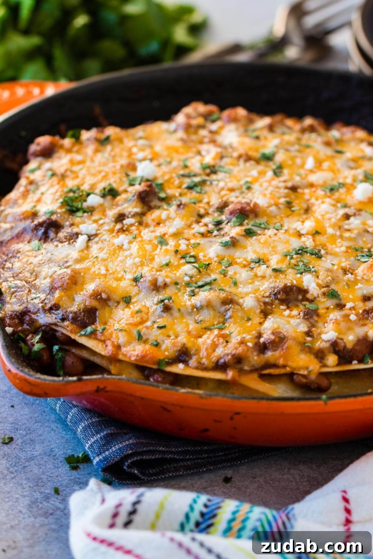 One Pan Cheesy Beef Enchilada Bake 5 a photo of a cast iron skillet full of ground beef enchilada casserole topped with melted cheese