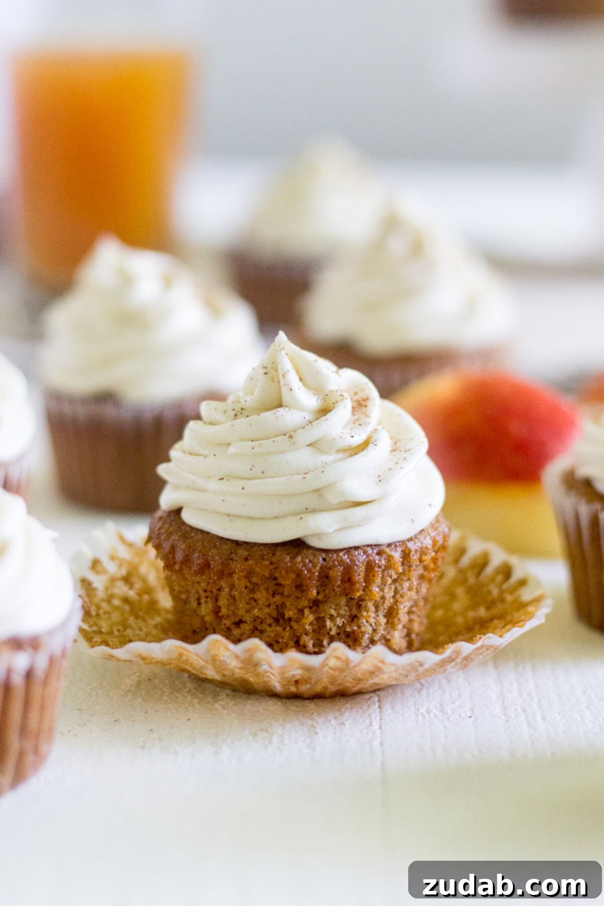 Warm Apple Cider Cupcakes with Spiced Cream Cheese Frosting 5 apple cinnamon cupcakes. the front cupcake has had the liner pulled down
