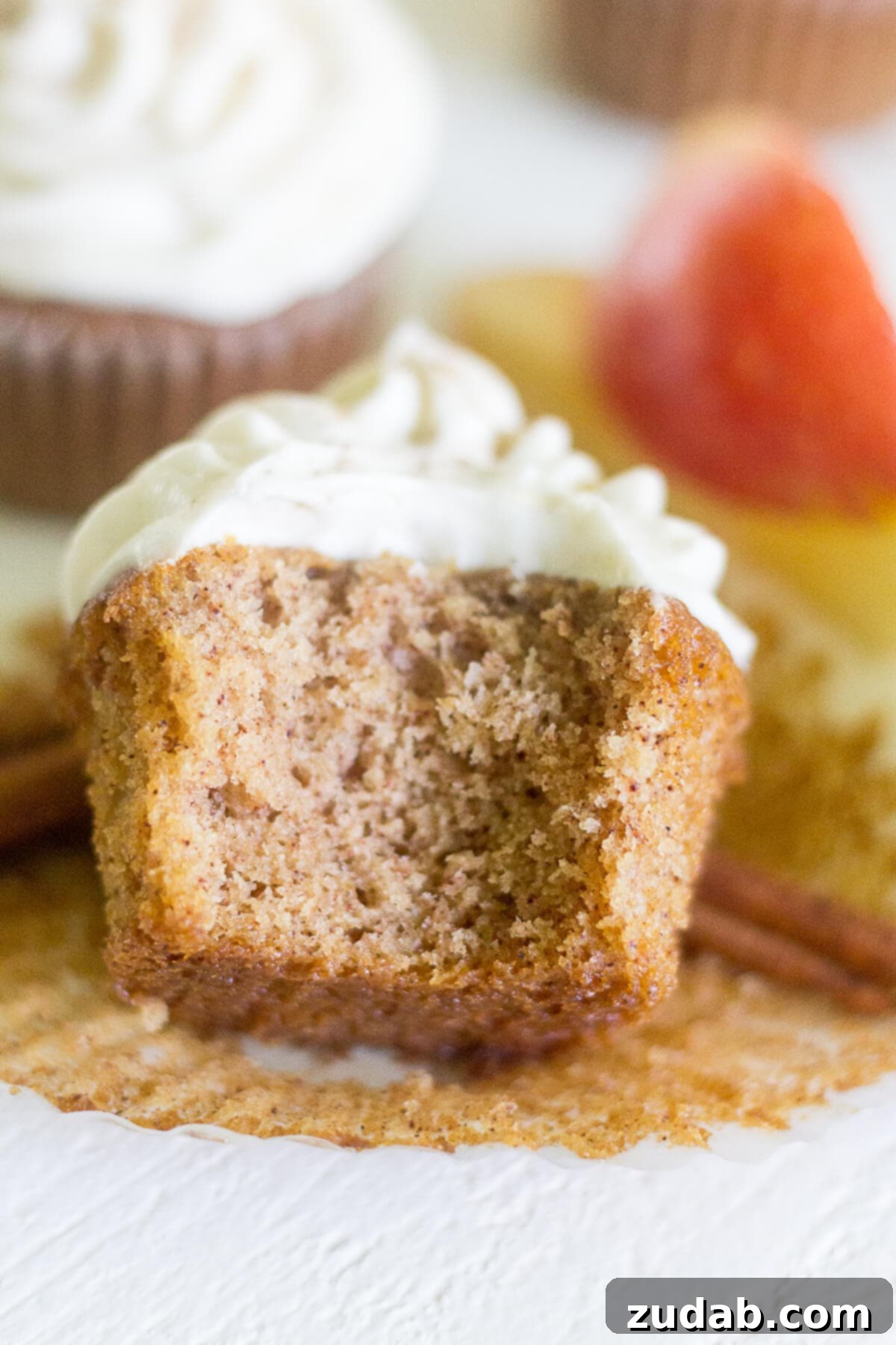 Warm Apple Cider Cupcakes with Spiced Cream Cheese Frosting 7 an apple cinnamon cupcake on its side with a bite missing