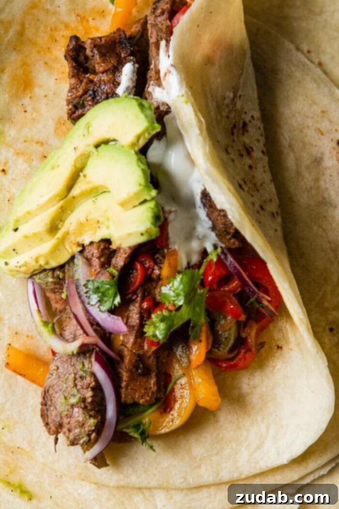 Our Secret Marinade for Tender Steak Fajitas 6 Close-up shot of a single, perfectly seared flank steak fajita strip, highlighting its tender texture