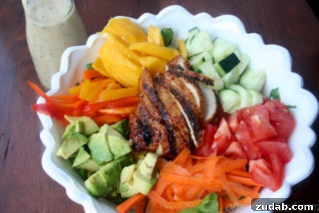Tropical Teriyaki Chicken Salad with Sesame Ginger Dressing 2 Colorful Teriyaki Chicken Salad with fresh mango, avocado, and Asian dressing on a white plate