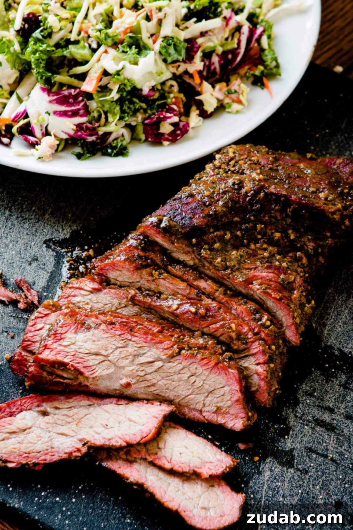 Smoky Samba: Traeger's Brazilian Tri-Tip 2 a photo of a smoked tri tip slitting on a cutting board that has been cut into slices so you can see the juicy center and pink smoke ring