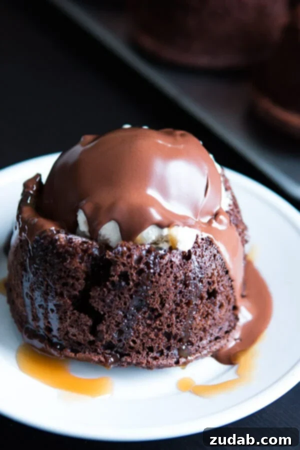 Copycat Chili's molten lava cakes recipe is way easier to make than you probably think and that hot fudge oozing out is such a crowd pleaser! Close-up of a perfectly baked Chili's copycat molten lava cake with a spoon breaking into the gooey, hot fudge center, ready to be topped with ice cream.