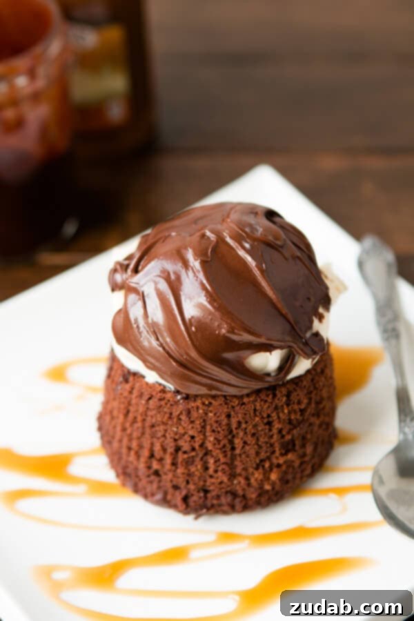 Copycat Chili's molten lava cakes recipe is way easier to make than you probably think and that hot fudge oozing out is such a crowd pleaser! A close-up shot of a molten lava cake, highlighting the rich, warm, gooey chocolate interior with a scoop of melting vanilla ice cream and a cherry on top.
