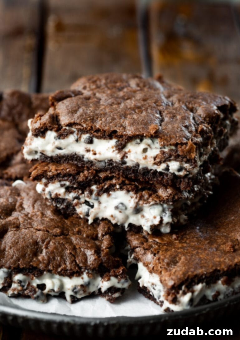 Ultimate Cookies and Cream Brownies 2 A photo of several fudgy cookies and cream brownies stacked, showcasing their distinct layers.