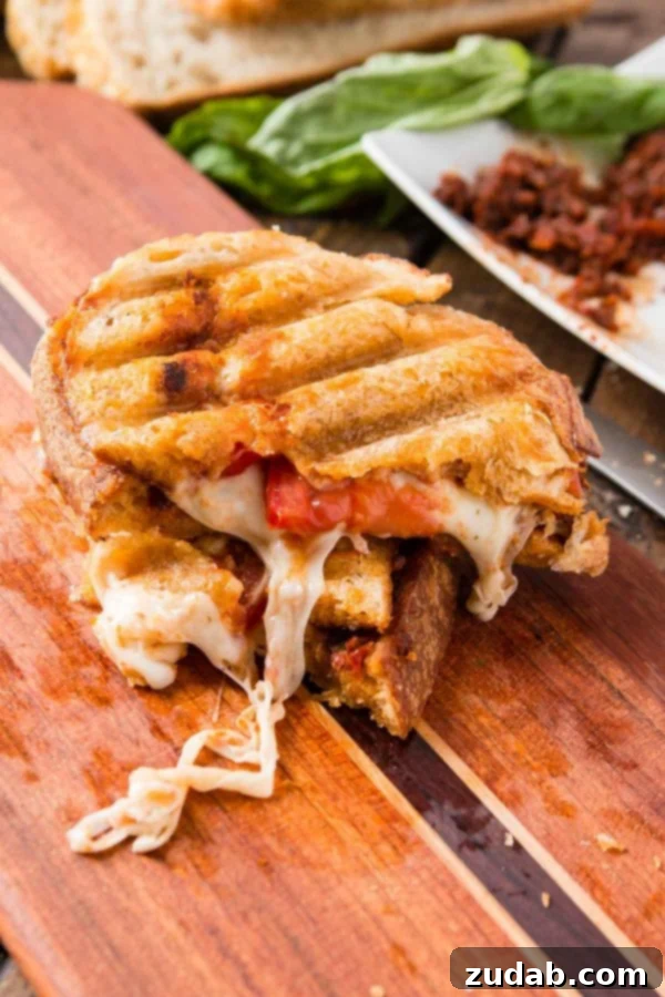 Key ingredients for Sun-Dried Tomato Pesto Panini Fresh ingredients laid out for Sun-Dried Tomato Pesto Panini: bread, mozzarella, tomatoes, and pesto