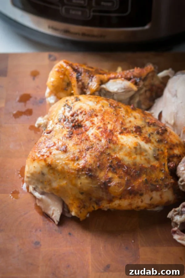 This is the easiest way to enjoy a juicy, rotisserie like chicken by only using a crockpot. Slow cooker whole chicken that anyone can make! insta pot, pressure cooker Whole Chicken on a wood cutting board.