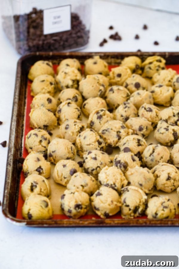 Chocolate Chip Cookie Dough Ready to Bake A sheet pan neatly arranged with balls of chocolate chip cookie dough, ready for baking.