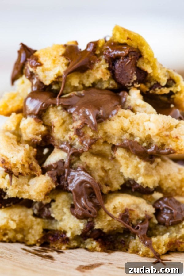 Stacked Chocolate Chip Pudding Cookies A stack of perfectly baked chocolate chip pudding cookies, showcasing their soft, chewy cross-section, loaded with melted chocolate.