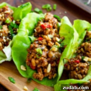 An appetizing photo of Thai Peanut Turkey Lettuce Wraps, featuring a vibrant lettuce cup filled with saucy ground turkey and a sprinkle of nuts, inviting you to taste.