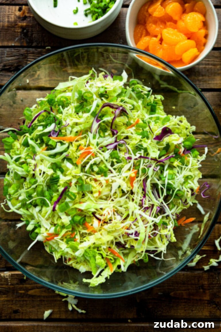 a photo of shredded cabbage and shredded carrot in a glass bowl.