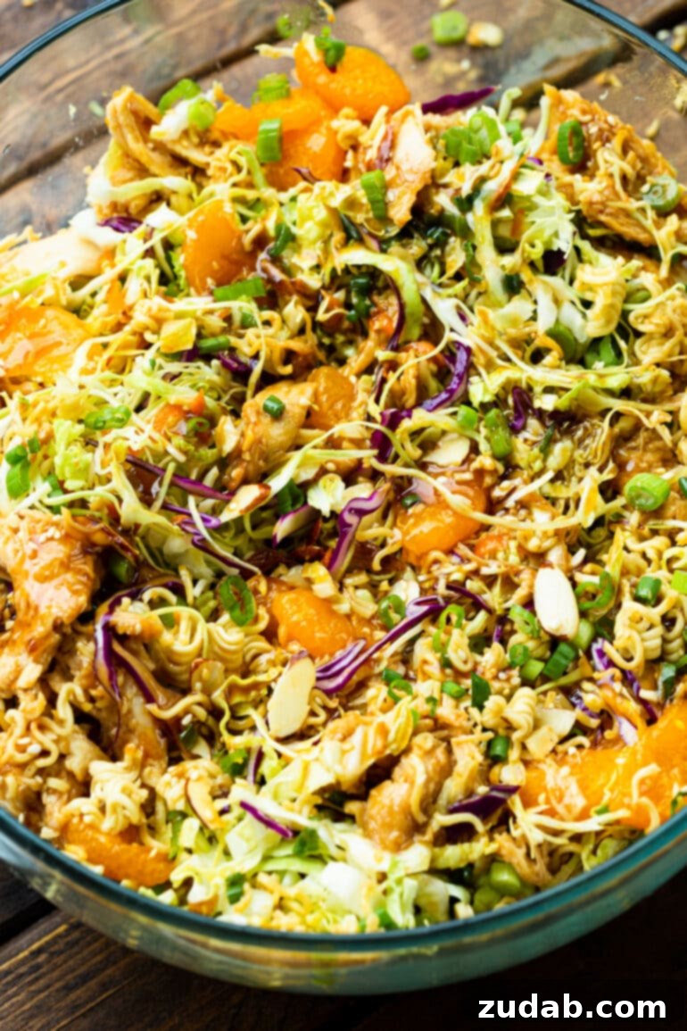 a photo of chinese chicken salad in a large glass serving bowl