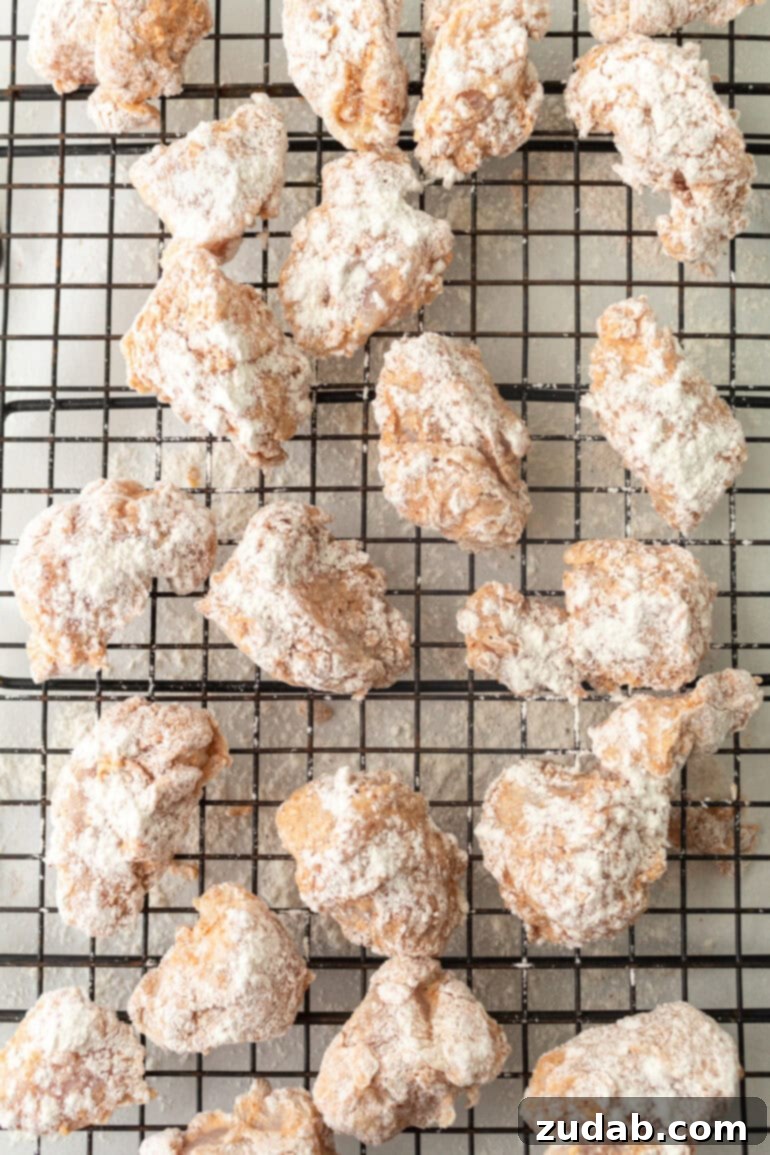 Several raw pieces of chicken that have been dredged in egg and flour, ready for frying.