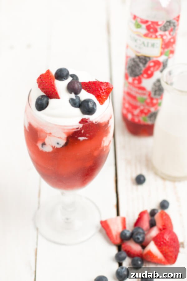 Botanical Lemonade Bliss 4 Refreshing Italian soda with colorful fruit slices and whipped cream.