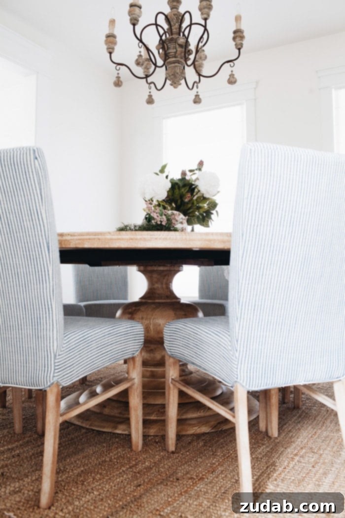Detailed shot of the round pedestal Monroe Dining Table, emphasizing its natural wood finish and suitability for intimate gatherings.