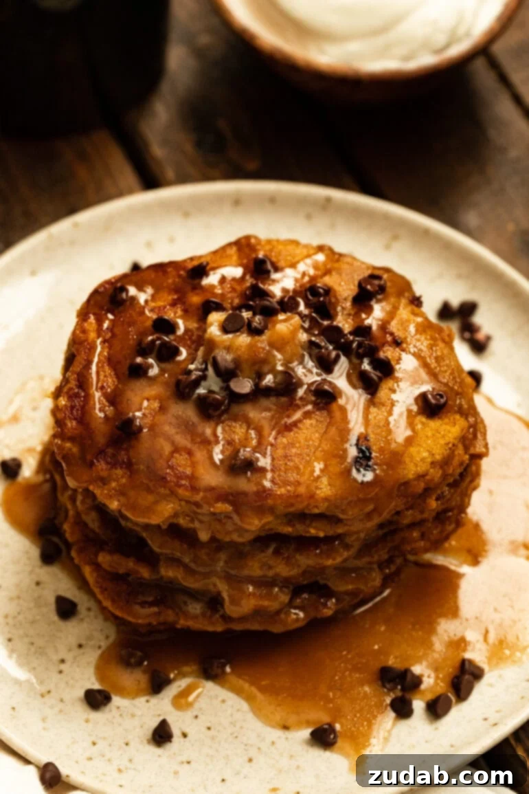 Homemade Whole Wheat Pumpkin Pancakes with Cinnamon Caramel Syrup 2 A glorious stack of whole wheat pumpkin pancakes drizzled generously with cinnamon caramel syrup and mini chocolate chips, perfect for a fall breakfast.
