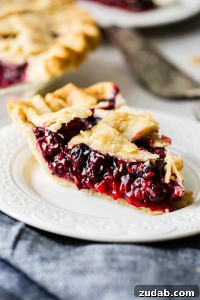 The Ultimate Razzleberry Pie 2 A slice of perfect razzleberry pie with a flaky crust, filled with raspberries, blueberries, and blackberries.
