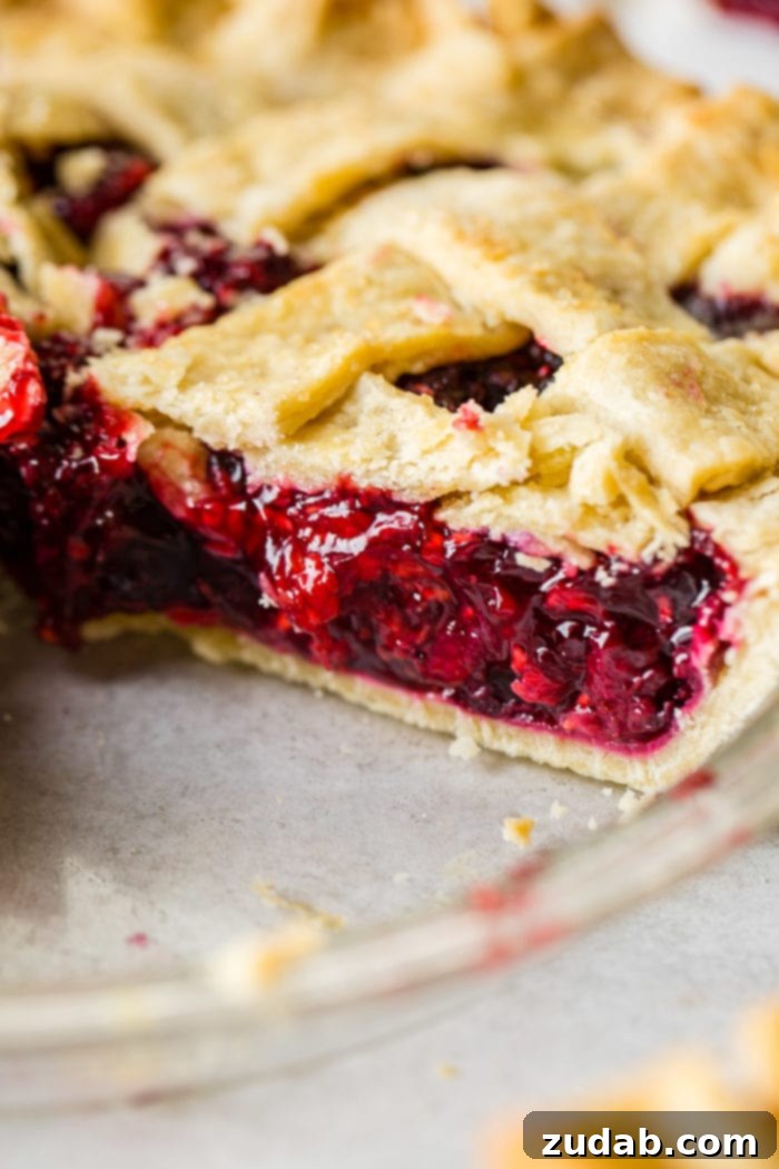 The Ultimate Razzleberry Pie 4 A whole razzleberry pie cooling on a wire rack, showcasing its golden lattice crust.