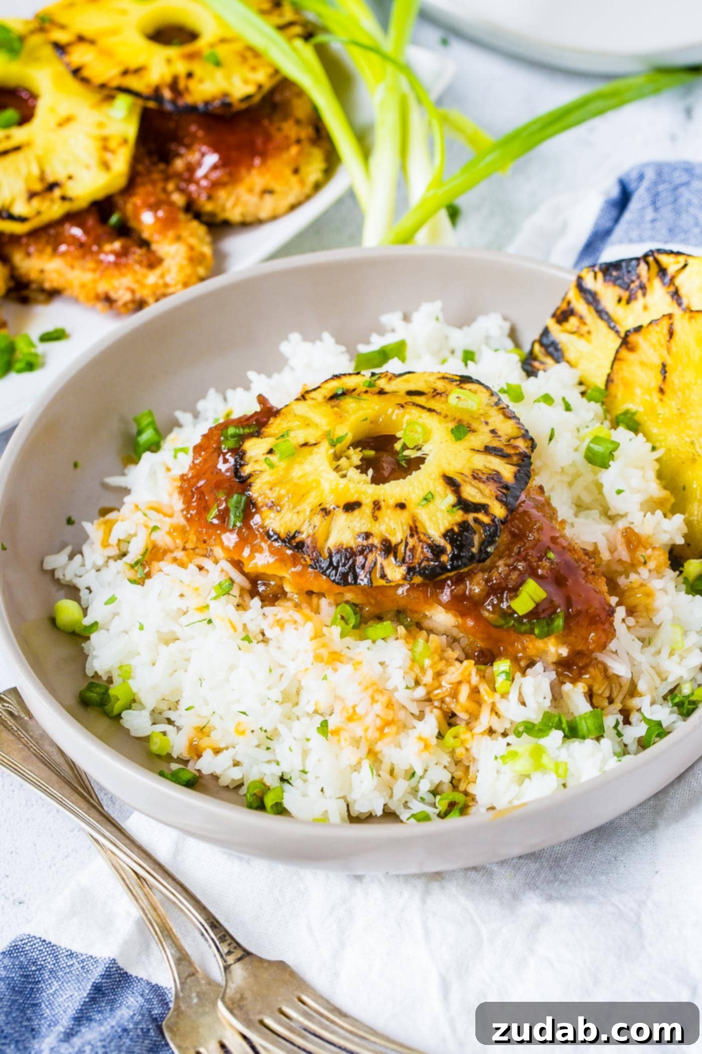 Speedy Sweet & Sour Pineapple Chicken 5 A bowl of white rice topped with breaded chicken sticky sauce chicken like sweet and sour sauce then a beautiful piece of grilled pineapple on top, ready for a quick and easy dinner
