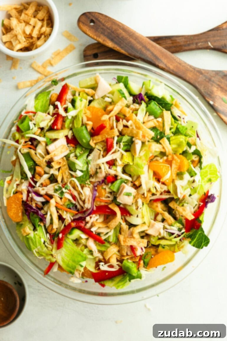 Crispy Wonton Chicken Salad 8 a large glass bowl full of Chinese chicken salad with wontons, garnished with fresh herbs