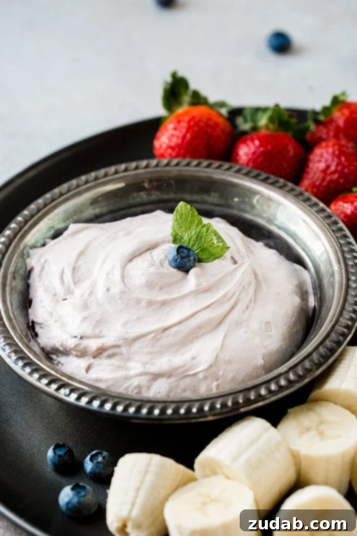 Blueberry Cloud Fruit Dip 4 A stunning shot of the 2-ingredient Blueberry Fluff Fruit Dip, a cream cheese dip exuding style, grace, and undeniable deliciousness. This easy recipe from ohsweetbasil.com is perfect for dipping fresh fruit and makes a chic addition to any party.