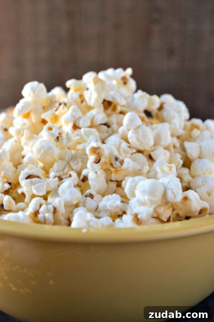 Tangy Salt and Vinegar Popcorn 4 A big yellow bowl of fluffy and light Salt & Vinegar popcorn, ready to be enjoyed as a healthier potato chip alternative for parties or game day.