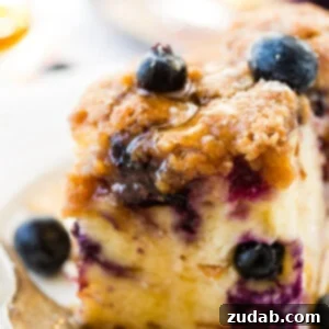 Blueberries on a piece of french toast bake or french toast casserole with maple syrup and a sprinkle of powdered sugar for a breakfast or brunch recipe with a vintage fork and white lace plate. Blueberry french toast bake 3 ways