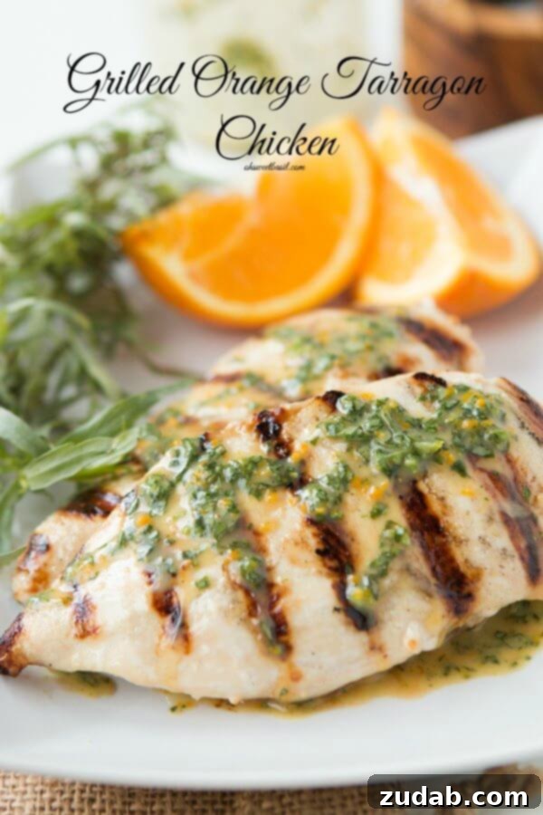 Grilled Orange Tarragon Chicken for a light but totally flavorful dinner. Close-up of a tender, juicy grilled chicken breast, glistening with orange tarragon marinade, with a side of sliced orange.