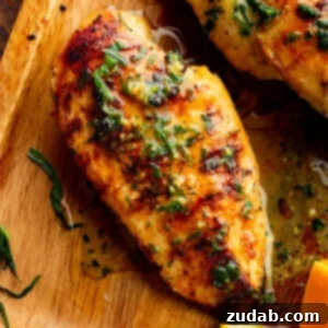 Zesty Orange Tarragon Grilled Chicken 2 Grilled chicken breast on a wooden cutting board, topped with chopped fresh tarragon and a glossy citrus marinade.