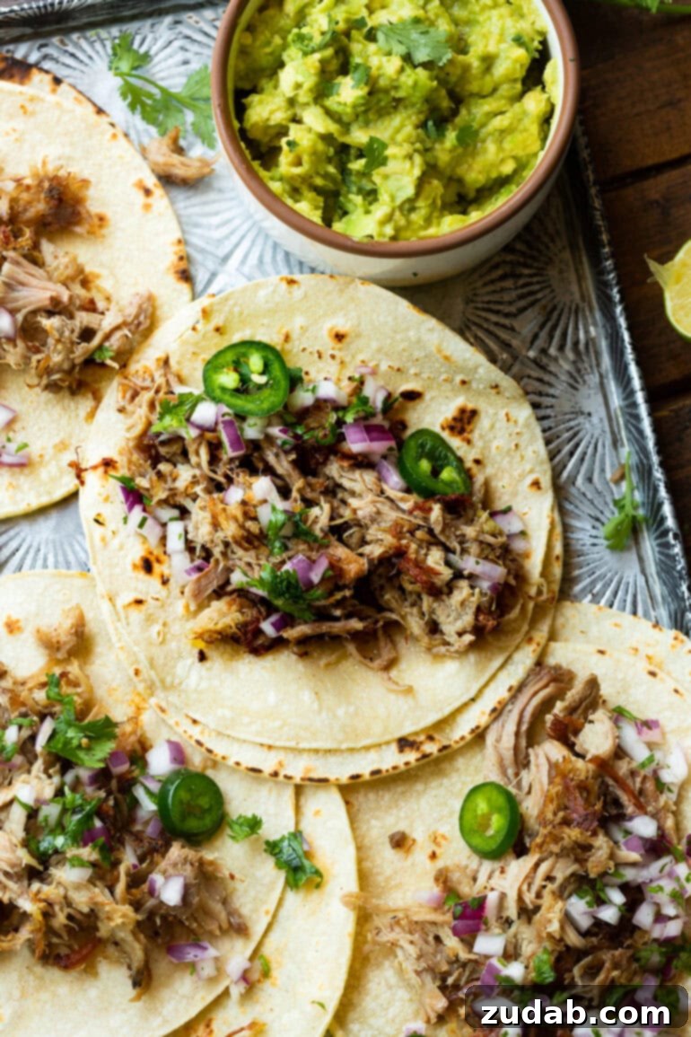 Crockpot Carnitas: Crispy & Juicy Pulled Pork 6 A vibrant spread of open flour tortillas, each generously topped with succulent pork carnitas, bright sliced jalapeños, fresh chopped red onion, and verdant chopped cilantro.