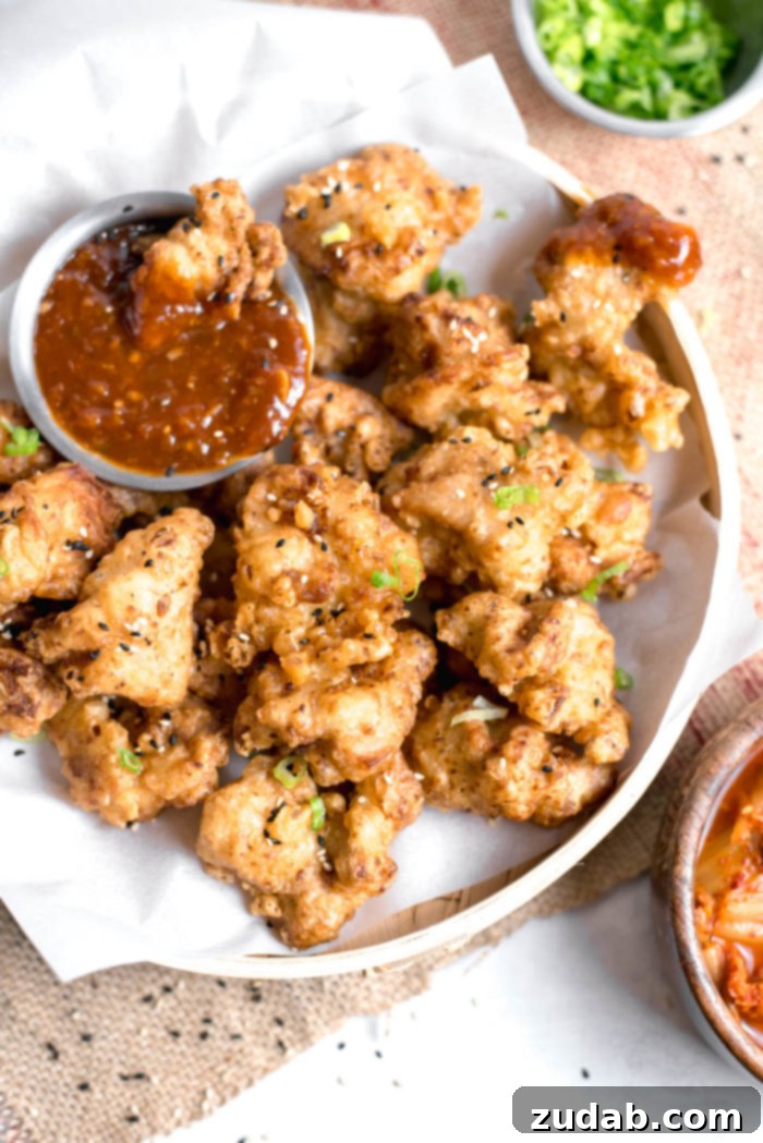 Crispy Korean Fried Chicken 2 Crispy Korean Style Fried Chicken coated in a glossy, sweet, and spicy Gochujang sauce, garnished with sesame seeds.