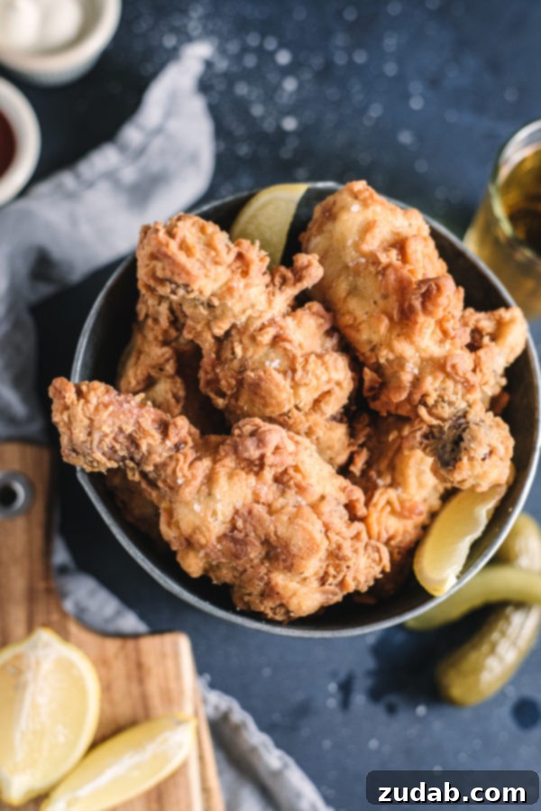 Crispy Korean Fried Chicken 10 Golden-brown Southern Style Fried Chicken pieces served in a basket with a side of dipping sauce.