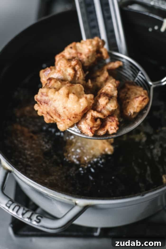 Crispy Korean Fried Chicken 5 Several golden-brown pieces of Korean Style Fried Chicken arranged artfully on a serving platter, ready to be coated with sauce.