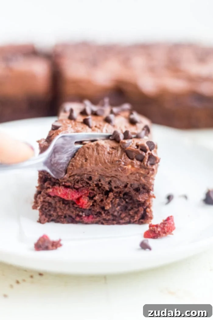 Dark Chocolate Cherry Indulgence 3 fork sliding into piece of chocolate cherry cake on plate