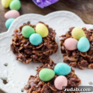 Three Easter Nest Cookies on a white plate topped with miniature eggs.