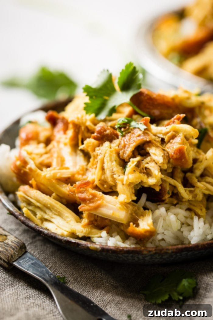 Instant Pot Sticky Honey Chicken 2 A metal, vintage bowl filled with white long grain rice and shredded chicken with a simple honey curry sauce made in an instant pot with cilantro on top. easy instant pot honey chicken
